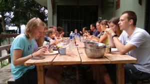 a group of people sitting around a wooden table at Naura Roomstay in Kuala Tahan