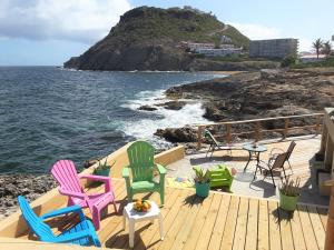 a deck with chairs and a table and the ocean at Ocean Shore in Philipsburg