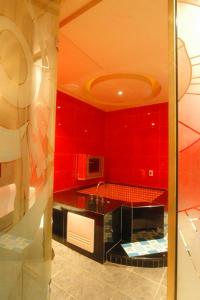 Zheng Yi Hotel & Motel I في مدينة تايتونج: مطبخ بجدران حمراء وقمة سوداء