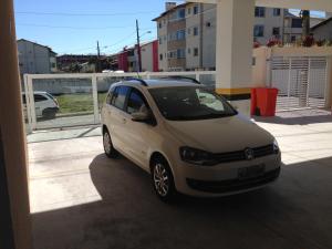 un pequeño coche blanco aparcado en un estacionamiento en Residencial Estrela Dalva- 450 metros do mar en Florianópolis