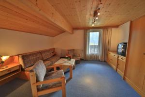 ein Wohnzimmer mit einem Sofa und einem TV in der Unterkunft Frühstückspension Jagdhof in Obertilliach