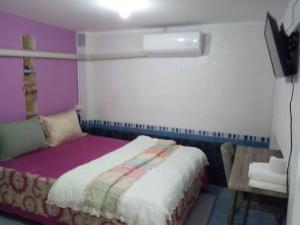 Schlafzimmer mit einem Bett, einem Tisch und einem TV in der Unterkunft Big Mango@88 house in Nonthaburi