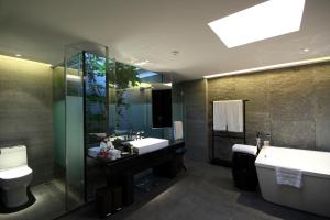 a bathroom with a sink and a tub and a toilet at Pullman Lijiang Resort & Spa in Lijiang