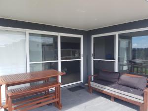 a living room with a couch and a table and windows at Hampton Homestay in Palmview