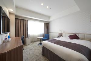 a hotel room with a large bed and a desk at HOTEL VISCHIO AMAGASAKI by GRANVIA in Amagasaki