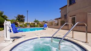 格伦多拉Best Western Route 66 Glendora Inn的一个带热水浴池和两把椅子的游泳池