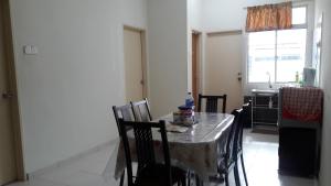 a table and chairs in a kitchen with a table and a window at HOMESTAY MURAH MELAKA Melayu Sahaja in Malacca +7 photos