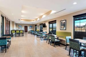 una sala da pranzo con tavoli, sedie e finestre di Comfort Inn & Suites Zion Park Area a Hurricane