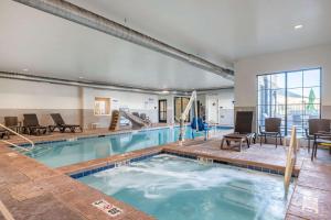 a pool in a hotel with chairs and a table at Comfort Inn & Suites Zion Park Area in Hurricane