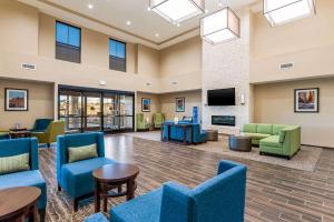 - un hall avec des chaises bleues et une télévision dans l'établissement Comfort Inn & Suites Zion Park Area, à Hurricane