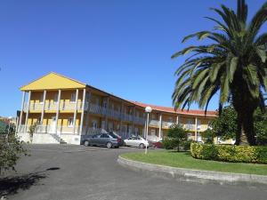 a large building with cars parked in a parking lot at Apartamentos San Pedro en Llanes in Llanes
