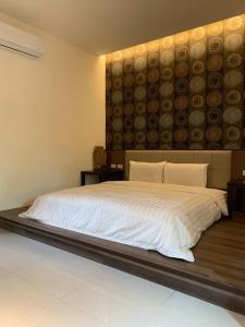 a bedroom with a large bed with a large headboard at 墾丁裡小路包棟Villa in Nanwan