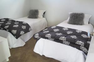 two beds with black and white blankets in a room at The Hideaway in Lake Tekapo