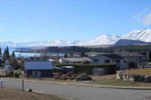 a view of a town with snow covered mountains at The Hideaway in Lake Tekapo