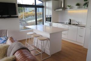 a kitchen with a counter and stools in a room at The Hideaway in Lake Tekapo