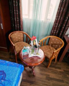 two chairs and a table with a bowl of flowers on it at Gold Beach Resort in Flic-en-Flac