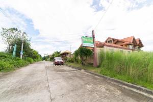 a street with a car parked on the side of a road at RedDoorz Plus @ Starhomes Olivianville in Tarlac