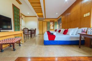 a bedroom with a large bed and a television at RedDoorz Plus @ Starhomes Olivianville in Tarlac
