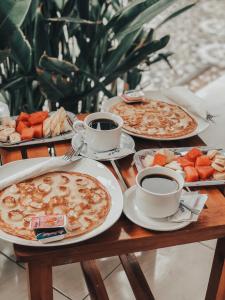 two pizzas and two cups of coffee on a wooden table at Cape Rose in Gili Trawangan