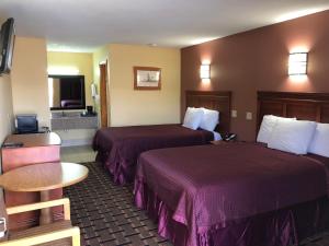 ein Hotelzimmer mit 2 Betten und einem Tisch in der Unterkunft Americas Best Value Inn-Indianola in Indianola