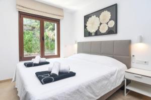 a white bedroom with a large bed and a window at Amipa by Aguilarent in Moraira +21 photos