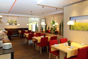 Hotel Silberhorn في نورنبرغ: غرفة طعام مع طاولات وكراسي حمراء
