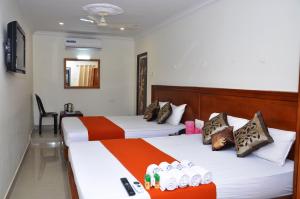 a hotel room with two beds and two lamps at Hotel NNP Grand - Fully Vaccinated Staff's in Rāmeswaram