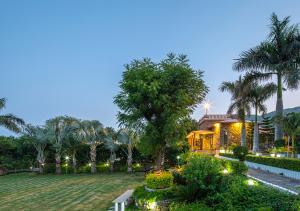a house with a garden at night with lights at Wild Orchid by StayVista, 2 BHK villa with a swimming pool, spacious lawn & a gazebo for a perfect getaway in Udaipur +10 photos