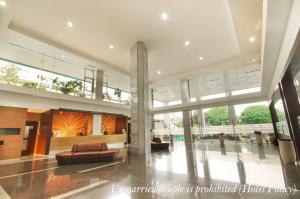 a lobby with a couch and chairs in a building at Hotel Gren Alia Jakarta in Jakarta