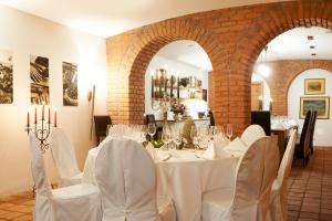 une salle à manger avec des tables et des chaises blanches et un mur en briques dans l'établissement Hotel & Restaurant Stern, à Gmünd
