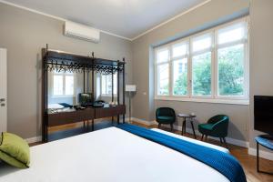 - une chambre avec un lit, un bureau et des fenêtres dans l'établissement Milano Manzoni CLC Apartments, à Milan