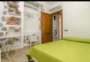 a bedroom with a green bed and a wooden door at Room Tortoli' in Tortolì