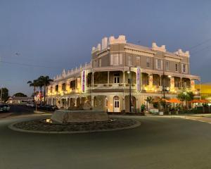 a large building with a fountain in the middle of a street at The Rose Hotel & Motel in Bunbury