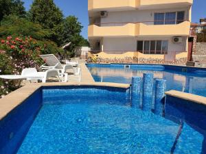 a swimming pool with chairs and a building at apartament Sea Star in Byala