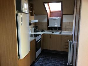 a small kitchen with a sink and a refrigerator at Nr. Nebel Minimarked in Nørre Nebel