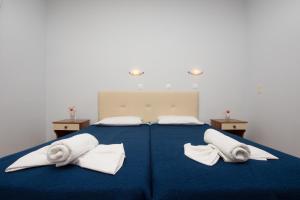 een groot blauw bed met twee witte handdoeken erop bij Villa Phoenix in Laganas