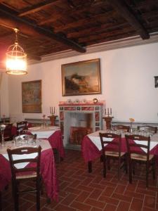 a dining room with tables and a fireplace at Palazzetto Leonardi in San Polo dei Cavalieri