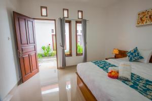 - une chambre avec un lit et une porte ouverte dans l'établissement Arie Guest House, à Nusa Penida