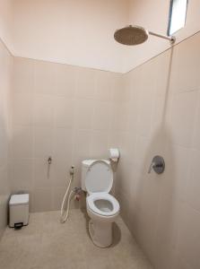 a bathroom with a toilet and a shower at Arie Guest House in Nusa Penida