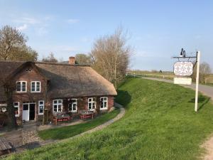 an old house on a hill next to a road at Bootfahrt in Tönning