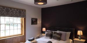 a bedroom with a bed and a black wall at The Three Horseshoes in Warham