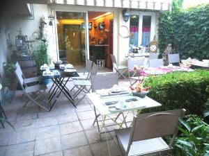 a patio with tables and chairs and a kitchen at Hôtel du Tricastin in Pierrelatte