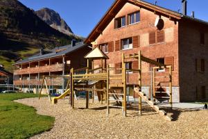 une aire de jeux avec toboggan en face d'un bâtiment dans l'établissement Alpenappartement Bergkönig, à Warth am Arlberg