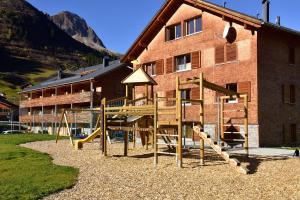a playground with a slide in front of a building at Alpenappartement Bergkönig in Warth am Arlberg