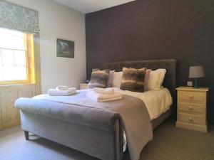 a bedroom with a large bed with towels on it at The Three Horseshoes in Warham