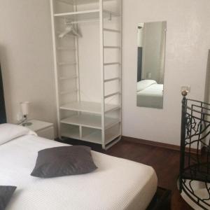 une chambre avec un lit blanc et un miroir dans l'établissement Gioiello di Venezia, Suite Calle del Forno, à Venise