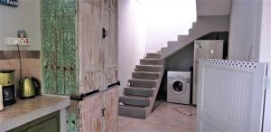 a laundry room with a staircase and a washing machine at Appartement Blue Coast in Mahébourg