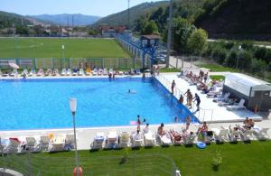 a large swimming pool with people sitting in chairs at Oras Zlatna in Zlatna