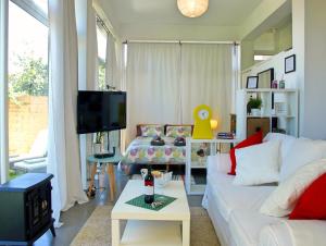 a living room with a white couch and a tv at Flatguest - Glass House in Santa Brígida