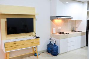 a kitchen with a flat screen tv on a counter at Lavenderbnb 1 at Uttara The Icon Apartment in Yogyakarta